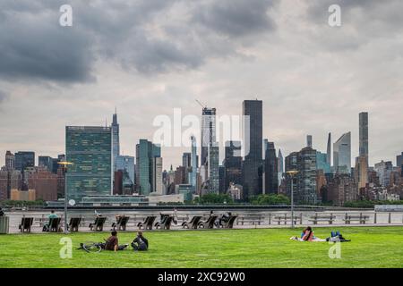 NEW YORK, États-Unis - 18 MAI 2024 : touristes et habitants de la région profitent d'un coucher de soleil printanier chaud au Gantry Plaza State Park à long Island City, avec Manhattan skylin Banque D'Images