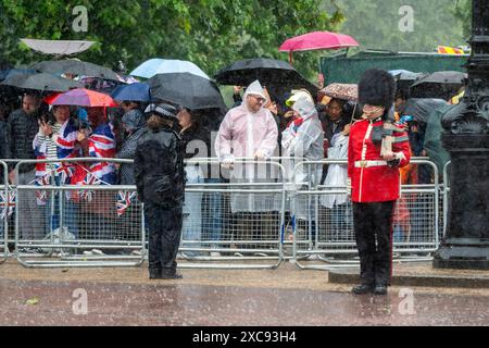 Londres, Royaume-Uni. 15 juin 2024. Une forte pluie tombe sur le Mall alors que la foule attend de voir le roi Charles et la famille royale retourner au palais de Buckingham après avoir triopé la couleur. Plus de 1 400 soldats de défilé, 200 chevaux et 400 musiciens participent à la cérémonie de Trooping the Colour (défilé de l'anniversaire du roi) pour marquer l'anniversaire officiel du souverain. Credit : Stephen Chung / Alamy Live News Banque D'Images