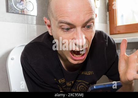 Homme blanc parlant au téléphone dans la salle de bain dans la journée Banque D'Images