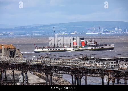 WESTON-SUPER-MARE, SOMERSET, Royaume-Uni, 15 juin 2024, le dernier bateau à aubes du monde, Waverley, traverse le canal de Bristol par l'historique Birnbeck Pier à Weston-super-Mare. Le Waverley est enregistré sur la National Historic Fleet comme étant un navire d'importance nationale prééminente, et a reçu le statut prestigieux de National Flagship of the Year 2024 par National Historic Ships UK. Crédit John Rose/Alamy Live News Banque D'Images