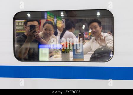 (240615) -- SHANGHAI, 15 juin 2024 (Xinhua) -- les passagers embarquant dans le train-couchette à grande vitesse D907 à destination de la gare de West Kowloon à Hong Kong font un adieu à la gare de Shanghai Hongqiao dans l'est de la Chine Shanghai, le 15 juin 2024. Les trains-couchettes à grande vitesse reliant Pékin et Shanghai à Hong Kong ont commencé à fonctionner samedi. Le temps de trajet entre Pékin et Hong Kong est réduit à 12 heures et 34 minutes, et le temps de trajet entre Shanghai et Hong Kong à 11 heures et 14 minutes. Avec les nouveaux services, les passagers peuvent voyager entre le grand-lan chinois Banque D'Images