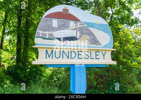 Mundesley, Royaume-Uni - 11 juin 2024 : le panneau du village pour Mundesley dans le nord du Norfolk, Royaume-Uni avec des arbres en arrière-plan Banque D'Images