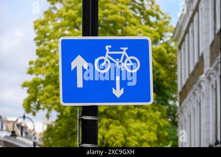 Londres, Royaume-Uni. Signe dans une rue à sens unique de Camden montrant que les cyclistes peuvent aller dans l'autre sens (vraisemblablement) Banque D'Images