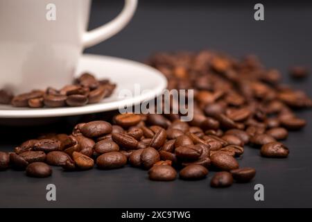 Gros plan d'une tasse à espresso avec grains de café Banque D'Images