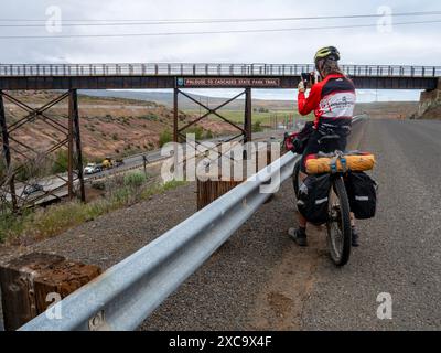 WA25390-00...WASHINGTON - Tom Kirkendall photographiant l'énorme panneau sur le pont sur la I-90 à l'est d'Ellensburg. Banque D'Images