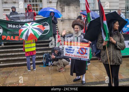 Londres, Royaume-Uni. 15 juin 2024. Lors du rassemblement devant la mairie de Hackney où le campement de Hackney Divest se trouve depuis plus d'un mois, appelant à la fin du génocide à Gaza et à la fin du jumelage du quartier avec Haïfa, Israël et jumeau avec la Palestine. Les discours et les bruyants tambours ont été interrompus une fois par des pluies torrentielles et se sont arrêtés plusieurs fois pour applaudir les mariages, une mariée agitant un drapeau palestinien et se joignant brièvement à la manifestation. Peter Marshall/Alamy Live News Banque D'Images