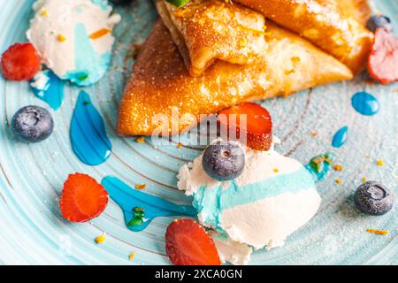 Crêpes aux fraises et aux bleuets, crème au fromage cottage avec sauce curaçao bleue. Gros plan. Photo de haute qualité Banque D'Images