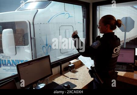 Un U.S. Customs and Border Protection préposé vérifie l'identification du conducteur du camion alors qu'il passe par le contrôle des États-Unis de la cargaison avant l'inspection à l'Otay Mesa, Californie, le port d'arrivée, le 22 juin 2016. Chaque jour, plusieurs centaines de camions alignés sur le côté mexicain de la frontière pour livrer les importations en attente en fin du processus de contrôle par les agents des douanes. Un nombre croissant de compagnies maritimes qui profitent de l'inspection du fret du CBP qui permet aux expéditeurs de confiance un moyen plus rapide et plus efficace de livrer des produits à des détaillants des États-Unis. Photo par Glenn Fawc CBP Banque D'Images