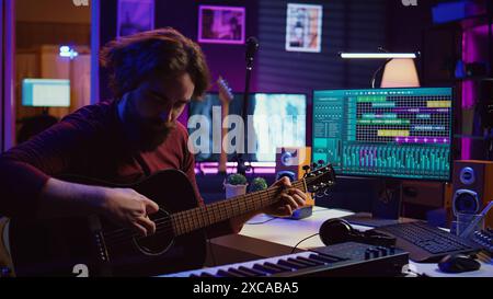 Musicien qualifié enseignant comment jouer de la guitare acoustique en ligne, la création de tutoriel Internet pour donner de l'aide avec l'instrument de musique. Auteur-compositeur artiste expliquant les accords et notes cordes. Caméra B. Banque D'Images