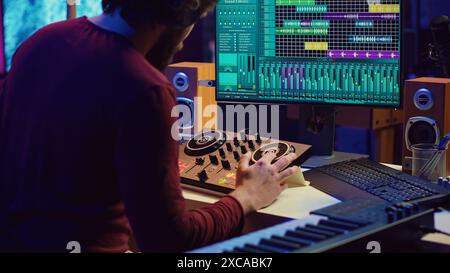 Ingénieur du son insérant une clé usb dans le pc pour s'enregistrer en jouant du piano, en mixant des sons et en réglant les niveaux de volume. Artiste mastering des enregistrements audio prêt pour la sortie. Caméra A. Banque D'Images