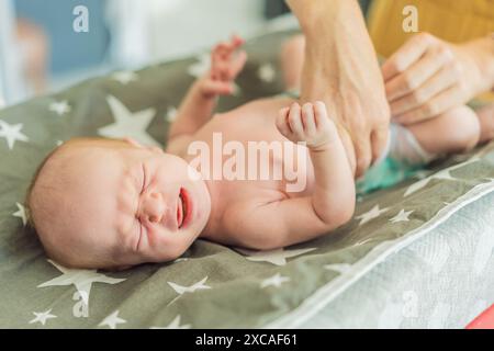 La peau du nouveau-né pèle. Maman utilise des produits pour la peau et des massages pour soigner et apaiser la peau délicate du bébé, assurant confort et promotion Banque D'Images