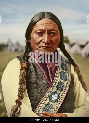 Portrait détaillé d’un leader autochtone dans le domaine des vêtements traditionnels. L'image capture le patrimoine culturel, l'histoire et la force, avec comme toile de fond des habitations historiques. Sit Bull (c. 1831-1890), né Tatanka Iyotake, était un chef Hunkpapa Lakota connu pour sa résistance contre les politiques expansionnistes américaines. Il a dirigé les tribus Oceti Sakowin (Sioux) dans leur lutte contre les colons dans le nord des grandes plaines. Il aide notamment à vaincre les troupes américaines lors de la bataille de Little Big Horn en 1876. Il reste un symbole des valeurs traditionnelles et de la résistance des Sioux Banque D'Images