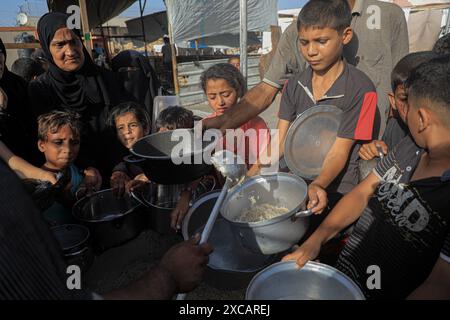 Gaza. 15 juin 2024. Le peuple palestinien reçoit une aide alimentaire dans la ville de Khan Younis, dans le sud de la bande de Gaza, le 15 juin 2024. Crédit : Rizek Abdeljawad/Xinhua/Alamy Live News Banque D'Images