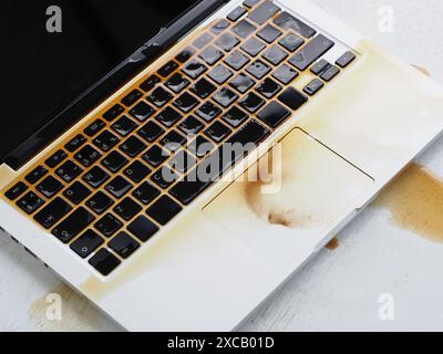 Café renversé sur le clavier de l'ordinateur portable. Ordinateur portable humide endommagé. Banque D'Images