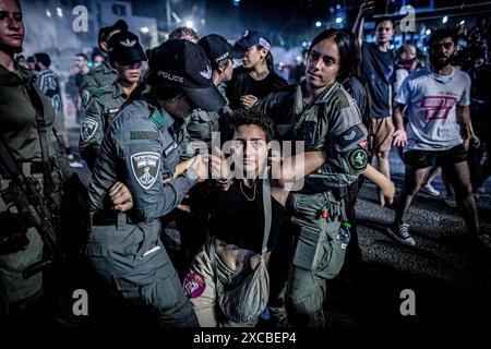 Des gardes frontière israéliens arrêtent un manifestant pendant la manifestation. Les manifestants se sont rassemblés dans des dizaines de lieux à travers Israël samedi soir pour appeler à mettre fin à la guerre à Gaza pour un accord d'otages et de nouvelles élections quelques heures seulement après la nouvelle de huit soldats israéliens tués dans une explosion à Rafah samedi matin. Banque D'Images