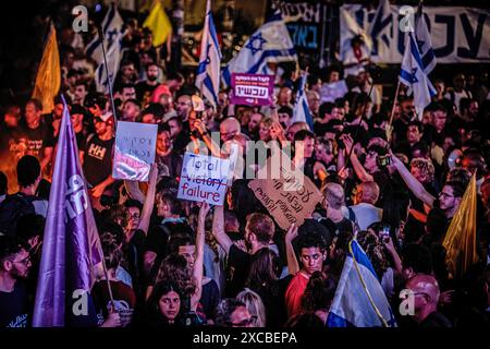 Les manifestants brandissent des pancartes pendant la manifestation. Les manifestants se sont rassemblés dans des dizaines de lieux à travers Israël samedi soir pour appeler à mettre fin à la guerre à Gaza pour un accord d'otages et de nouvelles élections quelques heures seulement après la nouvelle de huit soldats israéliens tués dans une explosion à Rafah samedi matin. Banque D'Images