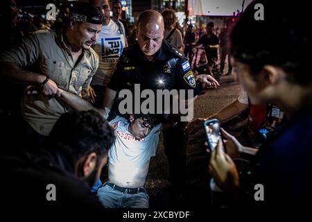 Tel Aviv, Israël. 15 juin 2024. Un policier israélien a arrêté un manifestant lors d'une manifestation à tel Aviv, le samedi 15 juin 2024. Des dizaines de milliers de manifestants se sont rassemblés dans des dizaines de lieux à travers Israël samedi soir pour appeler à la fin de la guerre à Gaza pour un accord d’otages et de nouvelles élections quelques heures seulement après la nouvelle de huit soldats israéliens tués dans une explosion à Rafah samedi matin. Photo par Eyal Warshavsky. Crédit : Eyal Warshavsky/Alamy Live News Banque D'Images