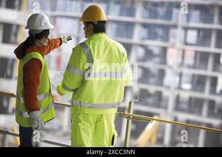 Techniciens avec vêtements réfléchissants et équipement de sécurité. Construction de logements, appartements. Saint-Sébastien, Gipuzkoa, Euskadi. Espagne. Banque D'Images