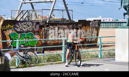 Brighton UK 16 juin 2024 - il est temps de se reposer pour ce cycliste Brighton après avoir terminé le 54 Mile British Heart Foundation London to Brighton Bike Ride aujourd'hui qui attire des milliers de coureurs chaque année : Credit Simon Dack / Alamy Live News Banque D'Images