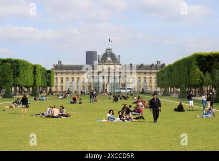 PARIS, FRANCE- 16 JUIN 2014 : touristes non identifiés et les populations locales se reposant sur l'herbe devant le vieux bâtiment historique avec drapeau français Banque D'Images