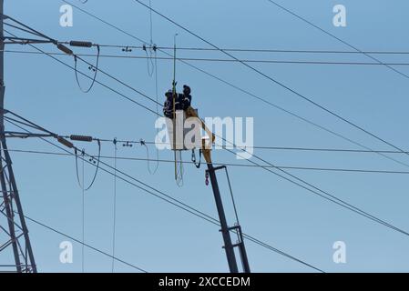 Hopefield, Western Cape, Afrique du Sud. 16. 04. 2024. Lignes électriques alimentant le réseau national en électricité avec des hommes travaillant à partir d'une cerise Banque D'Images