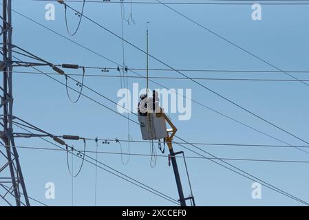 Hopefield, Western Cape, Afrique du Sud. 16. 04. 2024. Lignes électriques alimentant le réseau national en électricité avec des hommes travaillant à partir d'une cerise Banque D'Images