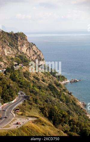 Mer bleue et montagnes vertes contre le ciel bleu. Route de montagne serpentine. Budva. Un voilier et un yacht sur la mer Adriatique. Printemps et été Banque D'Images