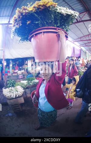 Vendeurs portant un panier de légumes ou de fleurs et le tenant sur votre tête pour l'emmener à son étal infreah marché du matin Banque D'Images
