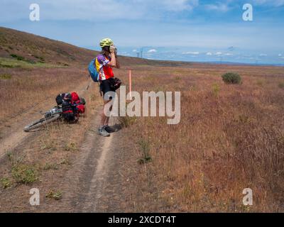 WA25411-00...WASHINGTON - Rider sur la route Cross Washington Mountain Bike le long d'une route isolée entre Ephrata et Moses Lake. Banque D'Images