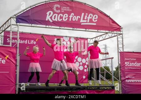Warrington, Cheshire, Royaume-Uni. 16 juin 2024. La course annuelle de 10 km « Race for Life » en soutien à cancer Research UK s'est tenue à Victoria Park, Warrington. Les instructeurs de gymnastique locaux ont demandé aux coureurs de s'échauffer avant la course crédit : John Hopkins/Alamy Live News Banque D'Images