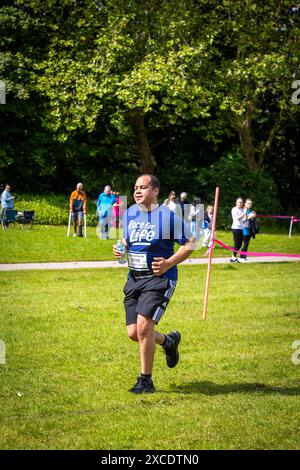 Warrington, Cheshire, Royaume-Uni. 16 juin 2024. La course annuelle de 10 km « Race for Life » en soutien à cancer Research UK s'est tenue à Victoria Park, Warrington. Le maillot mature Man in Race for Life s'attaque au parcours. Crédit : John Hopkins/Alamy Live News Banque D'Images