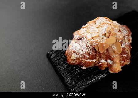 Croissant aux amandes. pâte feuilletée, délicate crème frangipane aux amandes, enrichie de beurre. Sur le dessus, le croissant a un soupçon de flocons d'amande et de pow Banque D'Images