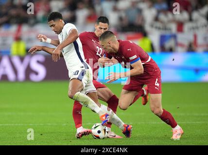 L'Anglais Jude Bellingham affronté par le serbe Sasa Lukic lors du match du Groupe C de l'UEFA Euro 2024 à l'Arena AufSchalke à Gelsenkirchen, Allemagne. Date de la photo : dimanche 16 juin 2024. Banque D'Images