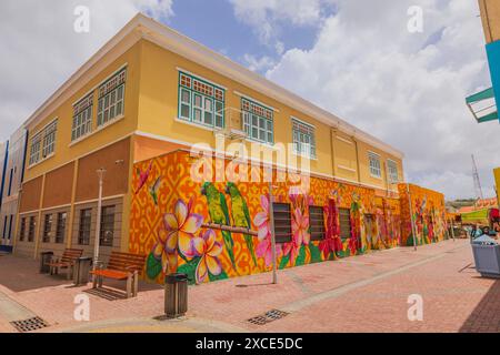 Belle vue sur un immeuble jaune-rouge orné de graffitis perroquets sur une des rues du centre-ville. Willemstad. Curaçao. Banque D'Images