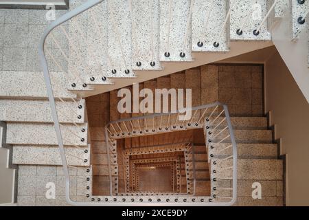 Vue aérienne rapprochée d'un escalier en colimaçon moderne. Les escaliers sont en marbre blanc et ont un design simple et courbé. Banque D'Images