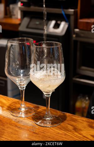 Versement spécial de txakoli ou chacolí vin blanc légèrement mousseux très sec dans des verres, produit dans le pays basque espagnol dans le bar pinchos typique Banque D'Images