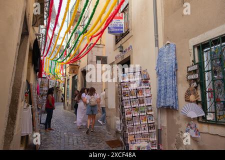Les gens marchent dans une rue étroite du quartier Alfama à Lisbonne, Portugal, pendant les festivités populaires des Saints Banque D'Images