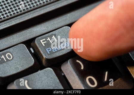 Doigt appuyant sur la touche pause sur un clavier d'ordinateur portable moderne, objet gros plan macro détail, une personne. Cliquer, mettre en pause une activité, prendre un br Banque D'Images