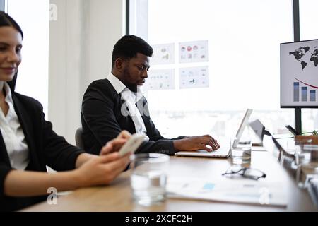 Équipe d'affaires dans le bureau moderne travaillant sur des appareils numériques Banque D'Images