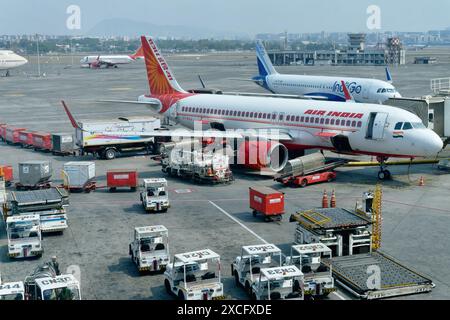 Avions d'Air India et Indigo sur le tarmac à l'aéroport international Chhatrapati Shivaji Maharaj à Mumbai, Inde, entourés de véhicules de service Banque D'Images