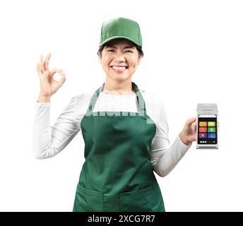 Vendeur asiatique porter tablier vert et chapeau vert souriant avec lecteur de carte tenant la main isolé sur blanc Banque D'Images
