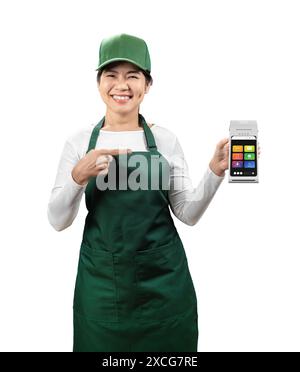 Vendeur asiatique porter tablier vert et chapeau vert souriant avec main tenant le doigt de lecteur de carte pointe isolé sur blanc Banque D'Images