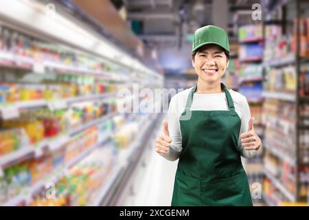 Vendeur asiatique porter tablier vert et chapeau vert souriant dans le magasin de détail Banque D'Images