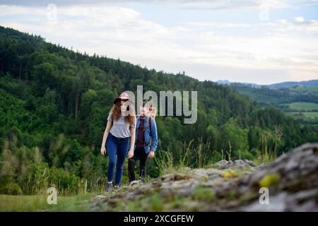 Les voyageurs couple randonnée sur un sentier facile dans la nature avec des sacs à dos. Jeune touriste au repos, bénéficiant d'une vue imprenable. Vacances d'été en plein air. Vue arrière Banque D'Images