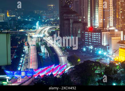 Illuminé par des lumières colorées, Saloma Link change de couleurs au hasard, avec le cimetière musulman au premier plan. Une autoroute et la rivière Klang courent par,Under Banque D'Images