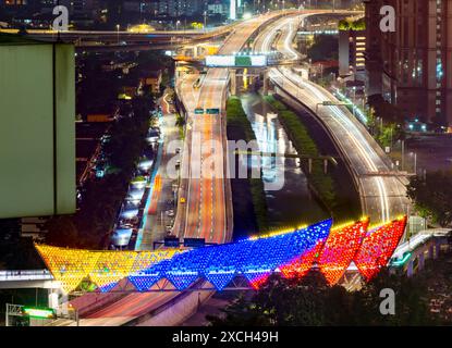 Illuminé par des lumières colorées, Saloma Link change de couleurs au hasard, avec le cimetière musulman au premier plan. Une autoroute et la rivière Klang courent par,Under Banque D'Images