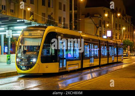 Un tramway CAF Urbos 3 par une soirée pluvieuse de nuit à Budapest, Hongrie Banque D'Images