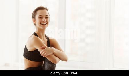Femme dans un soutien-gorge de sport noir souriant Banque D'Images