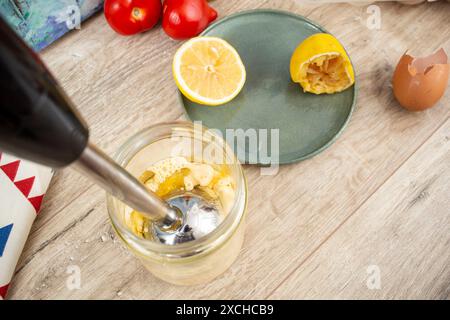 Préparation de mayonnaise dans un bocal en verre avec un mélangeur vertical à immersion, gros plan Banque D'Images