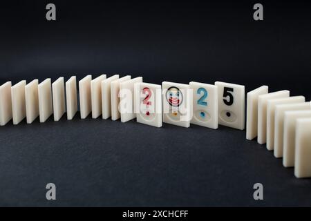 Tuiles Rummy arrangées avec 2025 numéros au milieu, bonne année avec effet domino, sur noir Banque D'Images